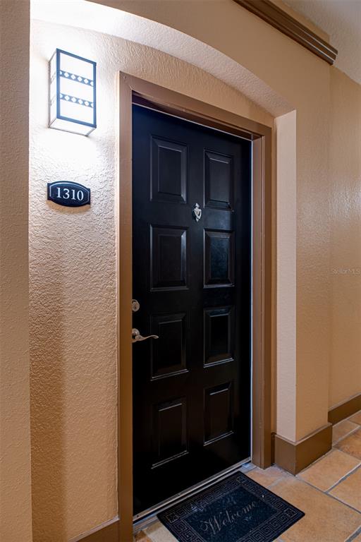A black front door with a silver knocker and a room number sign 1310 — 4221 W SPRUCE STREET UNIT 1310, TAMPA, FL
