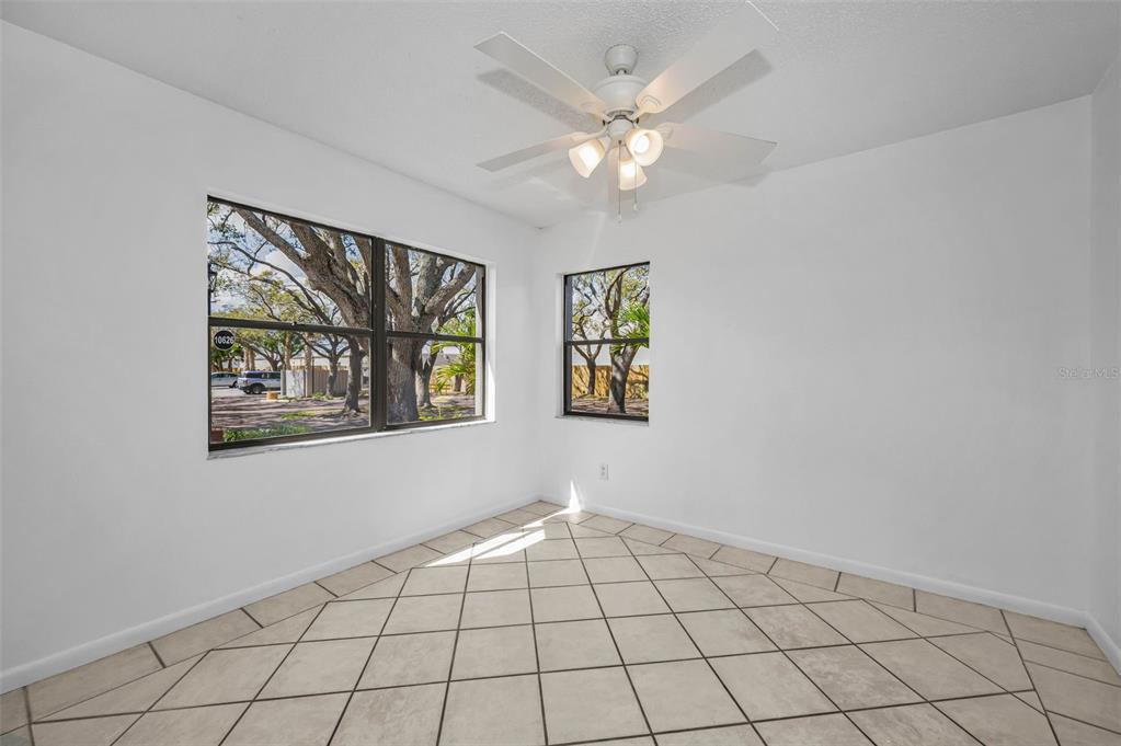An empty room with white walls, a ceiling fan, and light-colored diagonal floor tiles — 10626 LONGWOOD DRIVE UNIT 102, SEMINOLE, FL