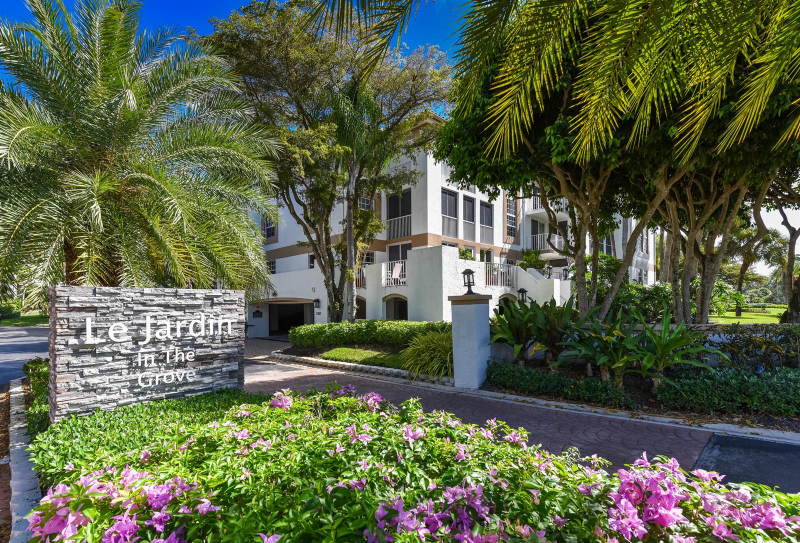 A stone sign for Le Jardin In The Grove stands before a multi-story apartment building — 7369 Orangewood Lane # 303, Boca Raton FL 33433, BOCA RATON, FL