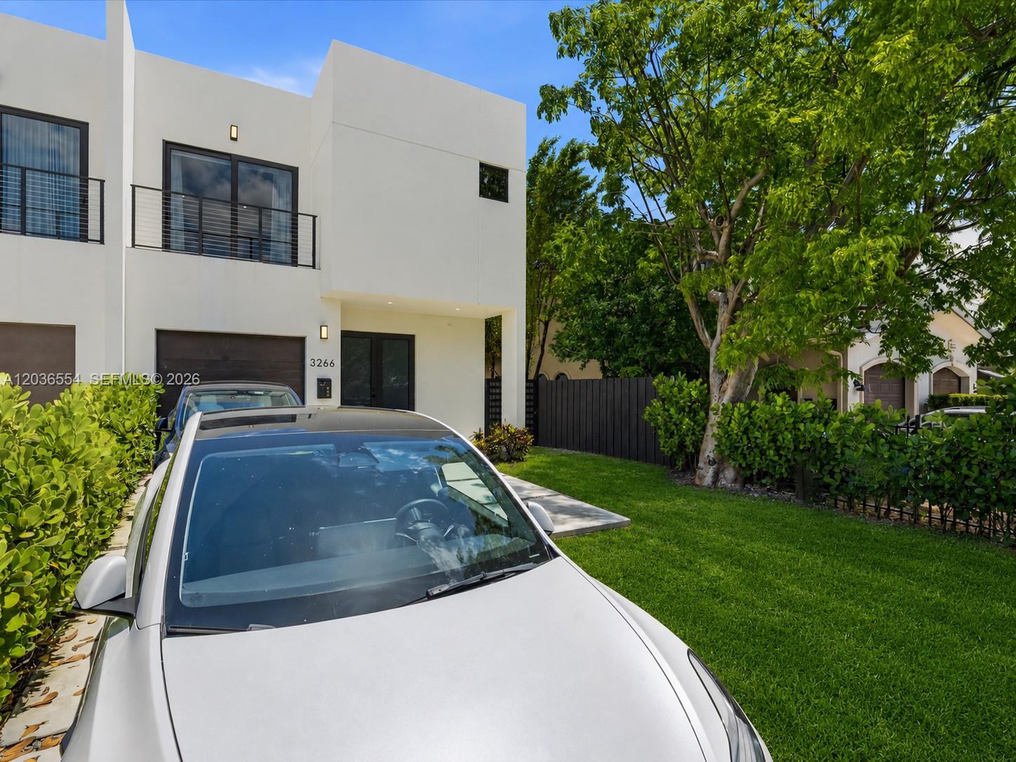 A modern white two-story house with a balcony and a car parked in the driveway — 3266 SW 25th Ter # 3266, Miami FL 33133, MIAMI, FL