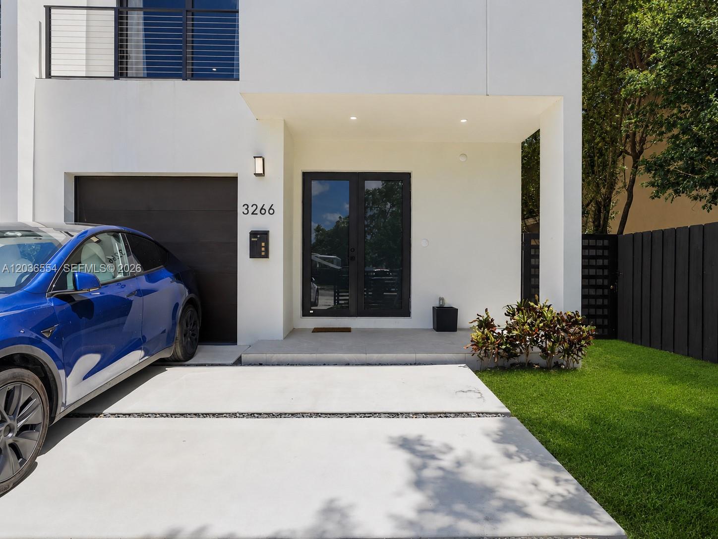 A modern white house exterior features a blue car parked on a concrete driveway — 3266 SW 25th Ter # 3266, Miami FL 33133, MIAMI, FL