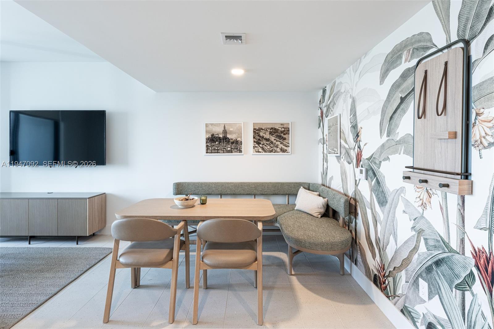 A dining area features a corner banquette, two chairs, a wooden table, and botanical wallpaper — 601 NE 1st ave # 3109, Miami FL 33132, MIAMI, FL