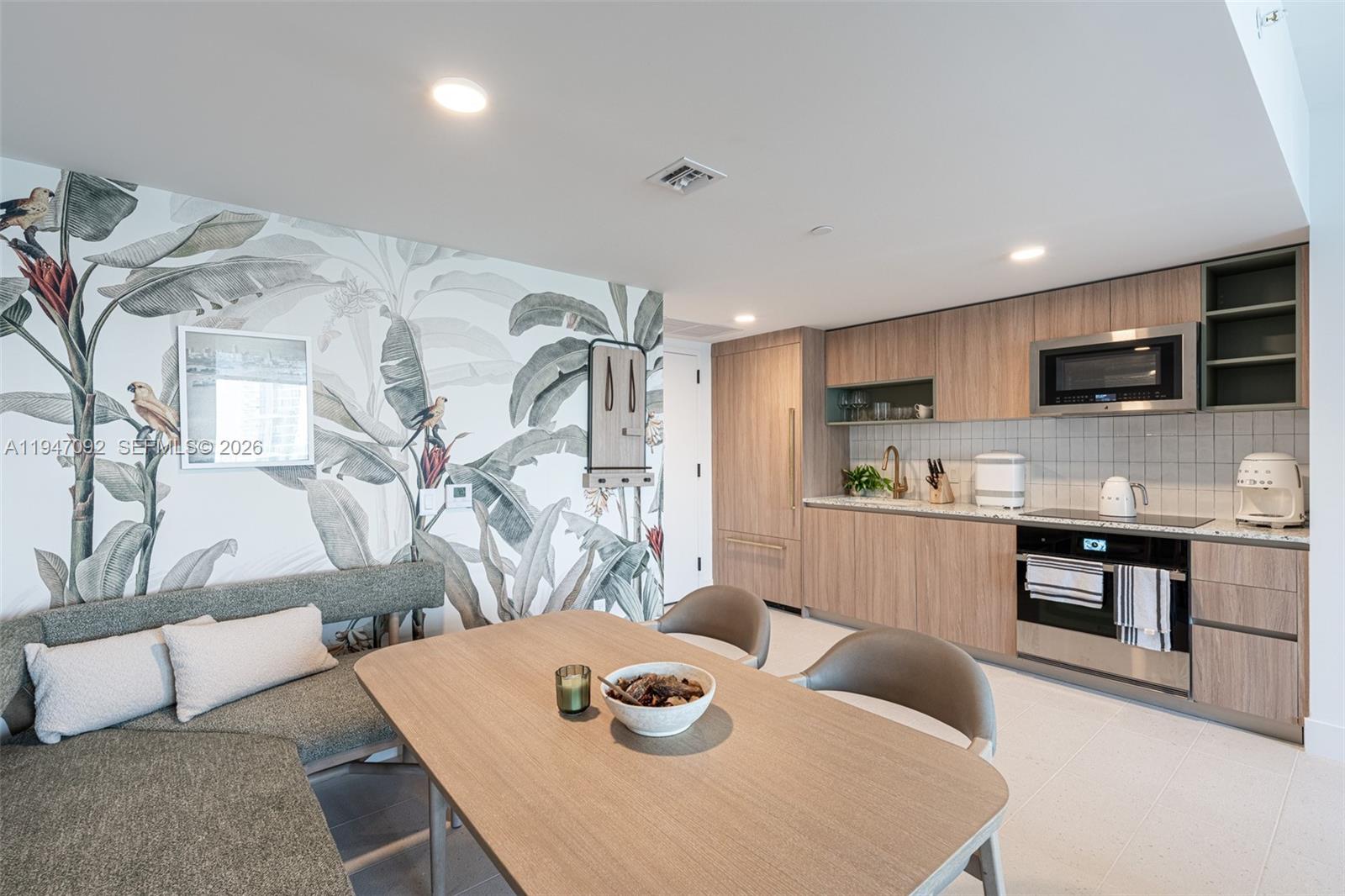 A kitchen and dining area features wood cabinetry, a botanical mural, and a corner bench — 601 NE 1st ave # 3109, Miami FL 33132, MIAMI, FL