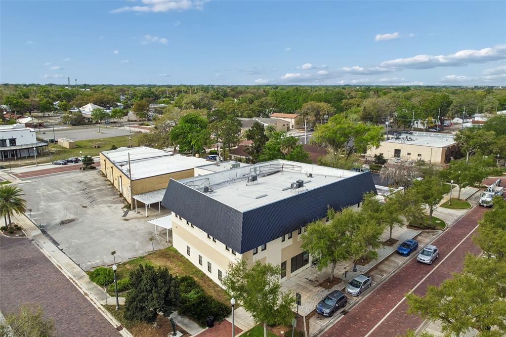 An aerial view shows a two-story commercial building with a dark mansard roof and parking — 201 W 1ST STREET, SANFORD, FL