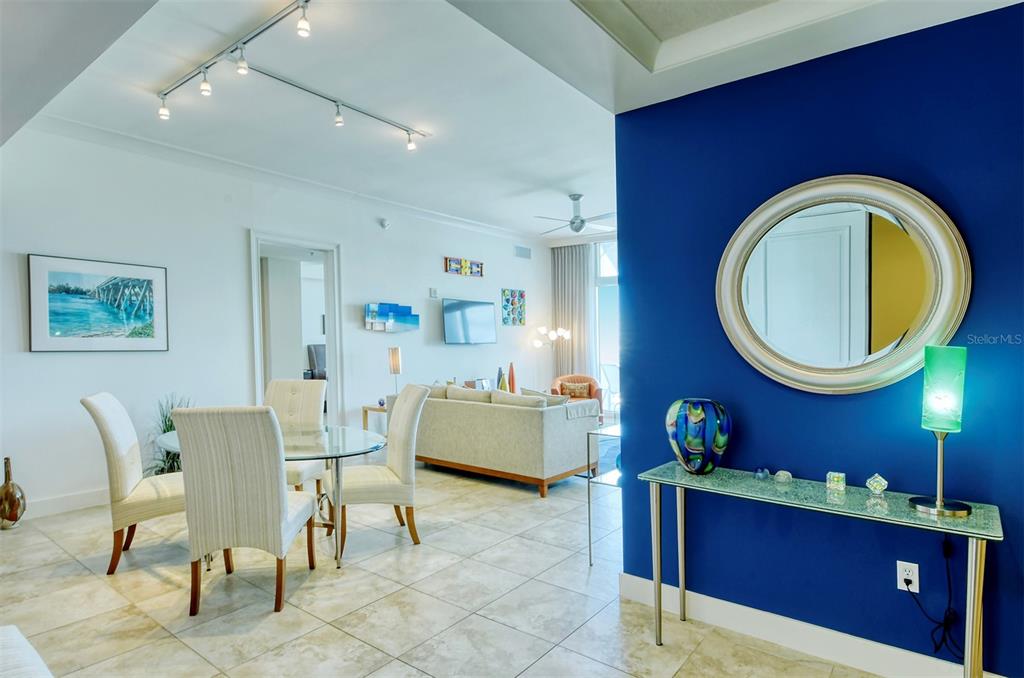 A dining area and living room feature tile floors, a blue accent wall, and track lighting — 1350 MAIN STREET UNIT 1702, SARASOTA, FL