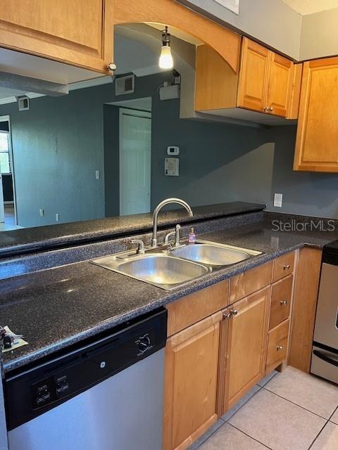 A kitchen features light wood cabinets, a dark granite countertop, and a stainless steel dishwasher — 10199 SAILWINDS BOULEVARD S UNIT 102, LARGO, FL