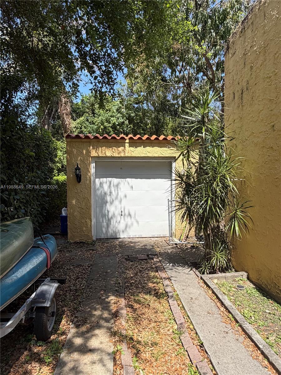 A detached single-car garage with a white door and a red tile roof — 1209 Mariana Ave, Coral Gables FL 33134, CORAL GABLES, FL