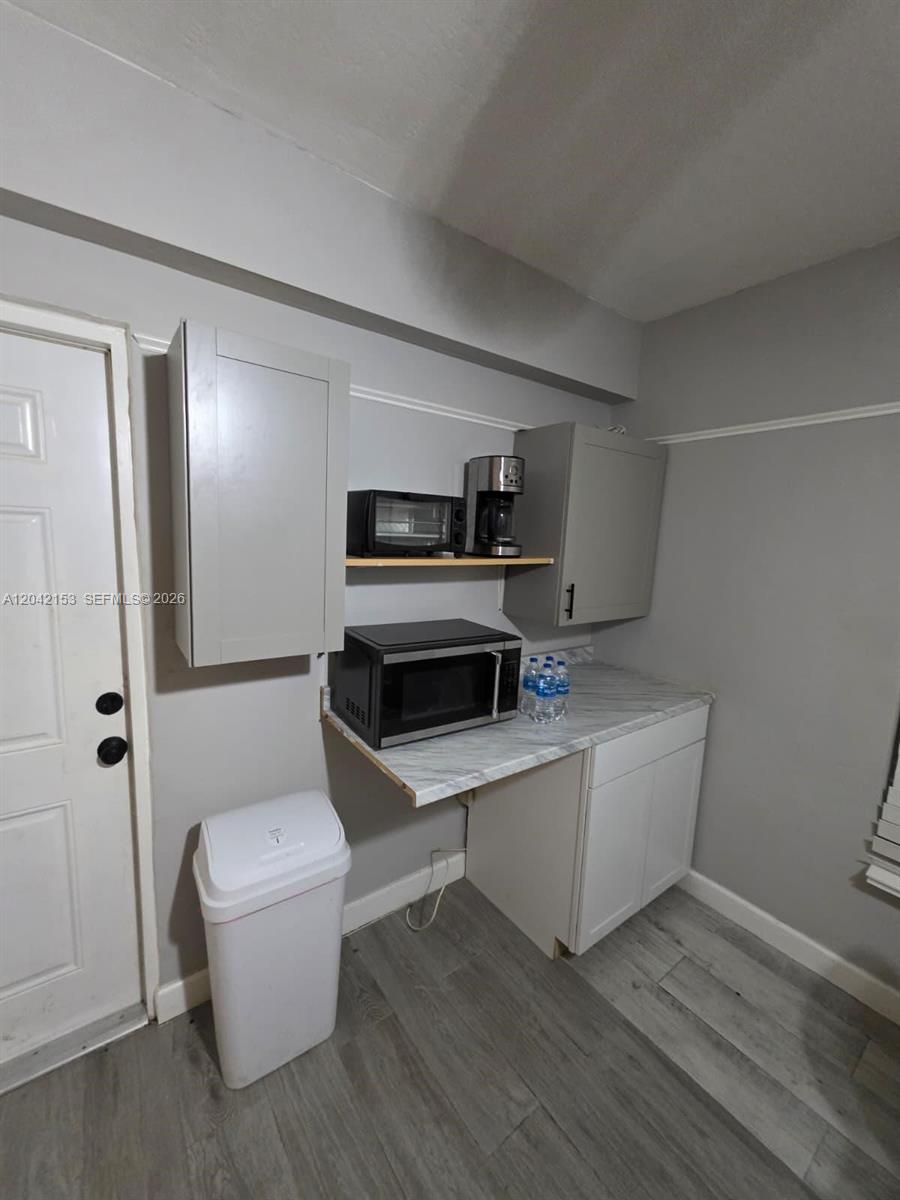 A small kitchen area features gray cabinets, a microwave, and a marble-patterned countertop — 6837 SW 39th Ter # 2, Miami FL 33155, MIAMI, FL