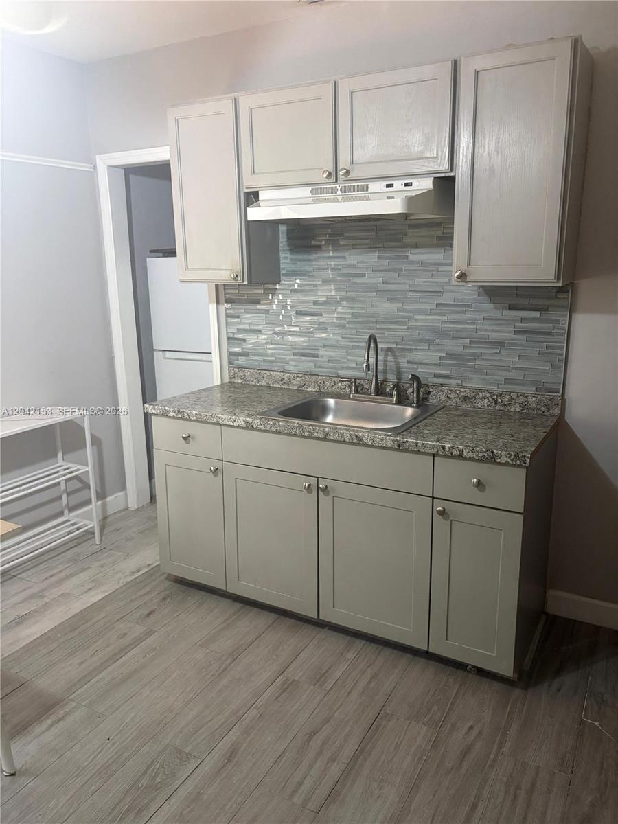 A kitchen features light gray cabinets, a granite countertop, a stainless steel sink, and backsplash — 6837 SW 39th Ter # 2, Miami FL 33155, MIAMI, FL