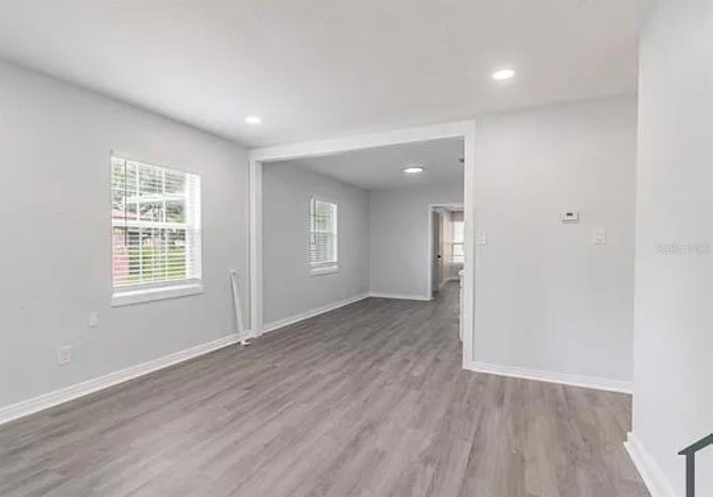 An interior view of a living area with light gray walls and wood-look flooring — 1706 W PALMETTO STREET, TAMPA, FL