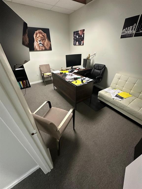 A home office features a desk, computer, seating, and wall art on a carpeted floor — 1340 CLEARMONT STREET NE UNIT 308, PALM BAY, FL