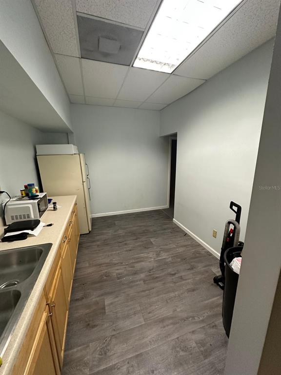 A small kitchen features light wood cabinets, a refrigerator, and gray wood-look flooring — 1340 CLEARMONT STREET NE UNIT 308, PALM BAY, FL