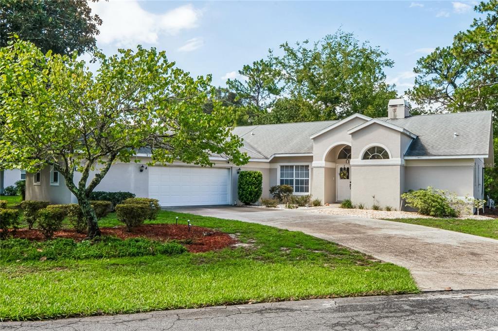 A single-story house with a white garage, arched entryway, and a concrete driveway — 4 SPRUCE PINE COURT N, HOMOSASSA, FL