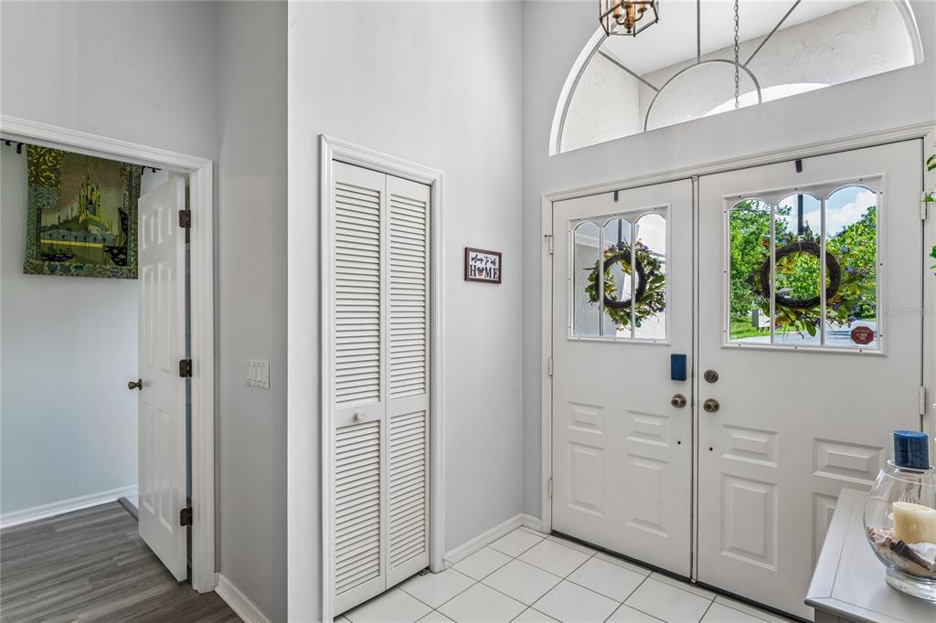 An entryway features white double doors, a louvered closet, tile flooring, and a vaulted ceiling — 4 SPRUCE PINE COURT N, HOMOSASSA, FL