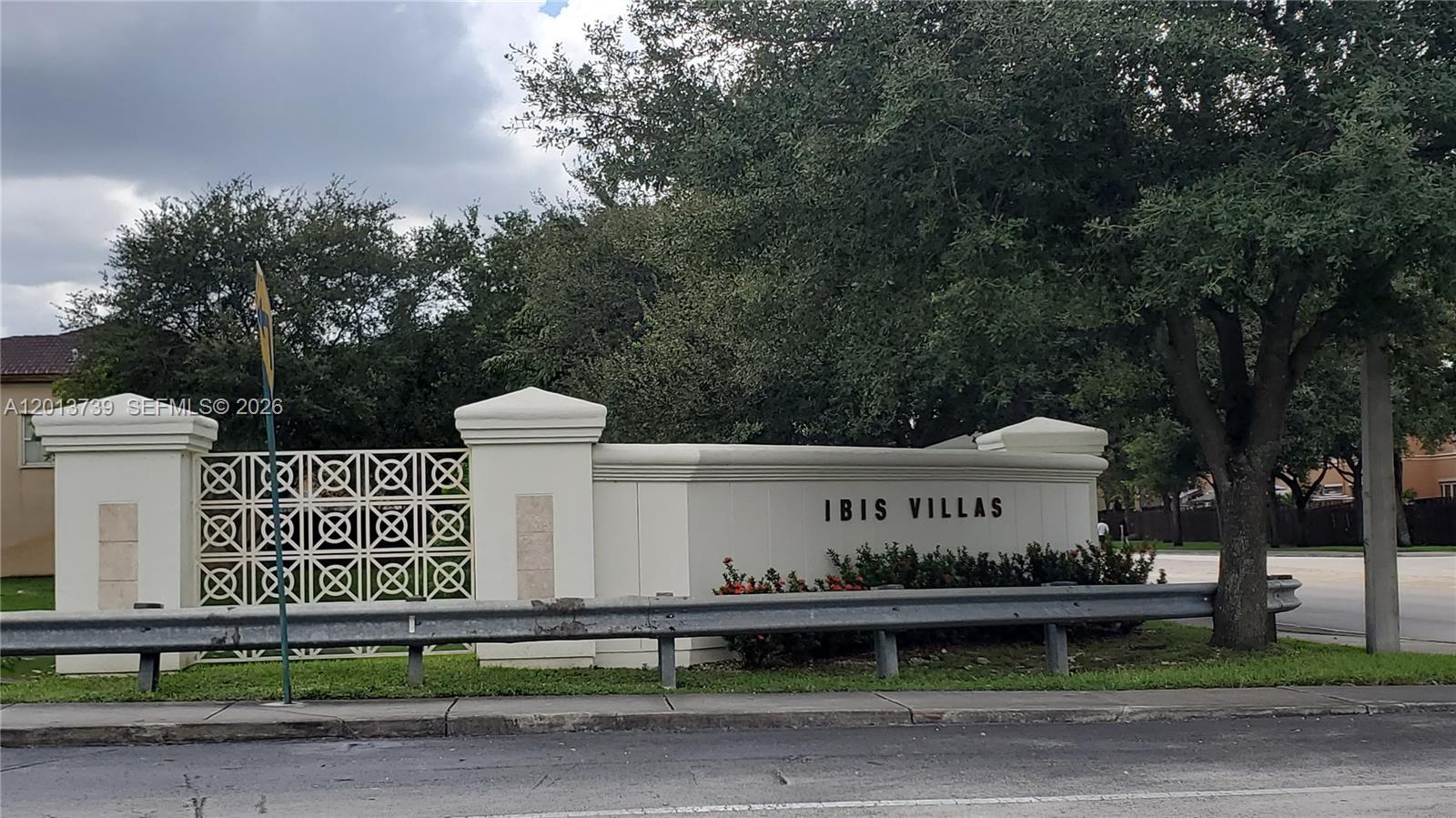 A white stucco wall with the text Ibis Villas stands behind a metal guardrail — 8804 NW 109th Pl # 402, Doral FL 33178, DORAL, FL