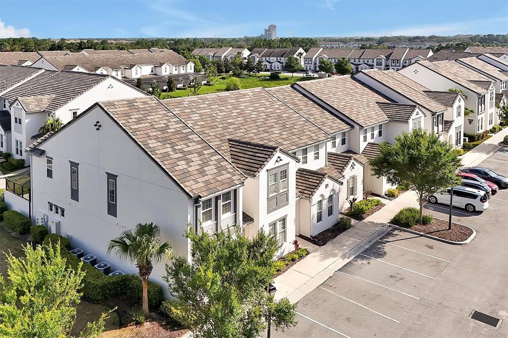 An aerial view shows a multi-story residential building with a tiled roof and parking lot — 297 CAPTIVA DRIVE, DAVENPORT, FL
