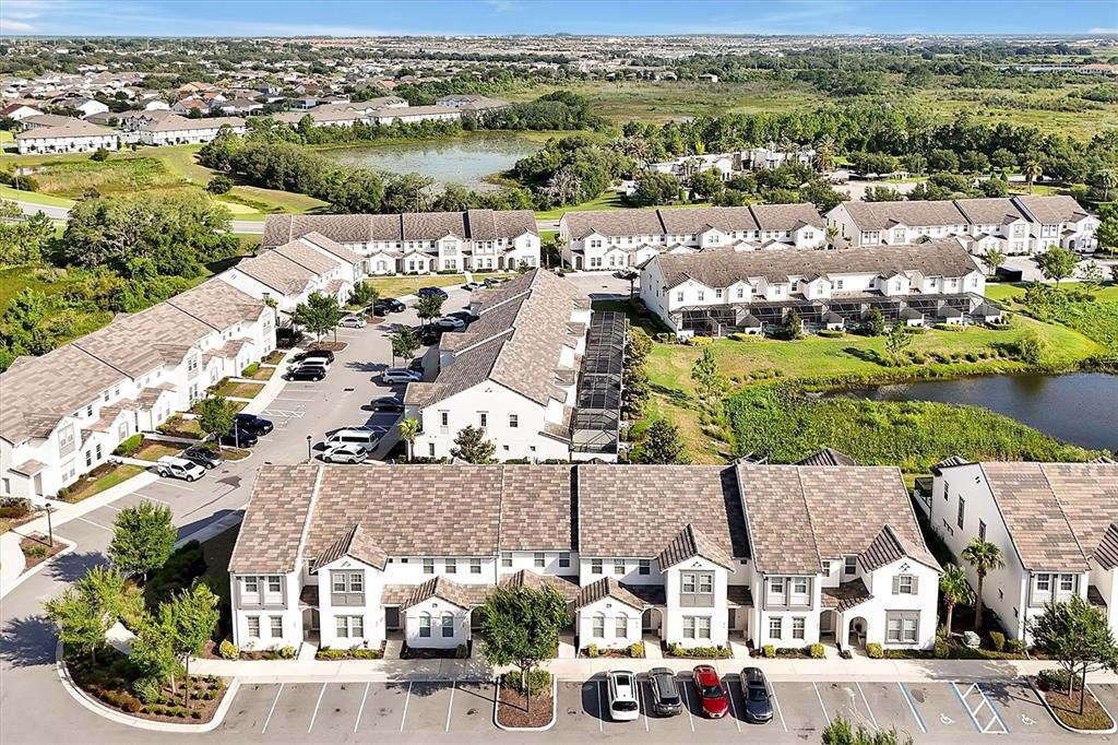An aerial view shows multiple rows of white townhomes with gray roofs and parking lots — 297 CAPTIVA DRIVE, DAVENPORT, FL