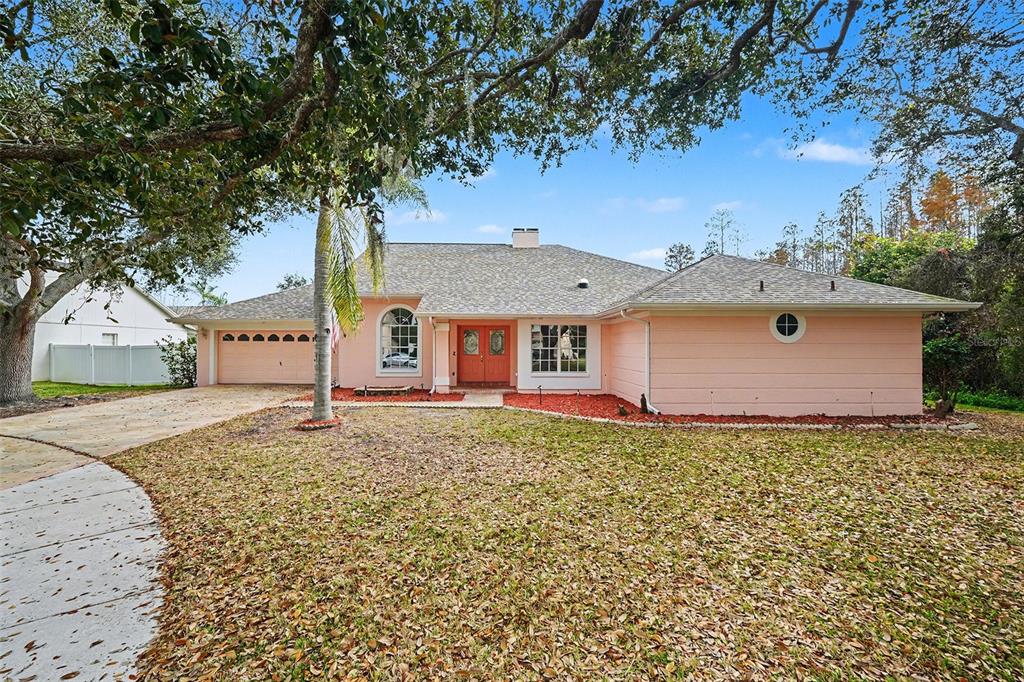 A single-story peach-colored house with a two-car garage and a large front lawn — 4814 TANNERY AVENUE, TAMPA, FL