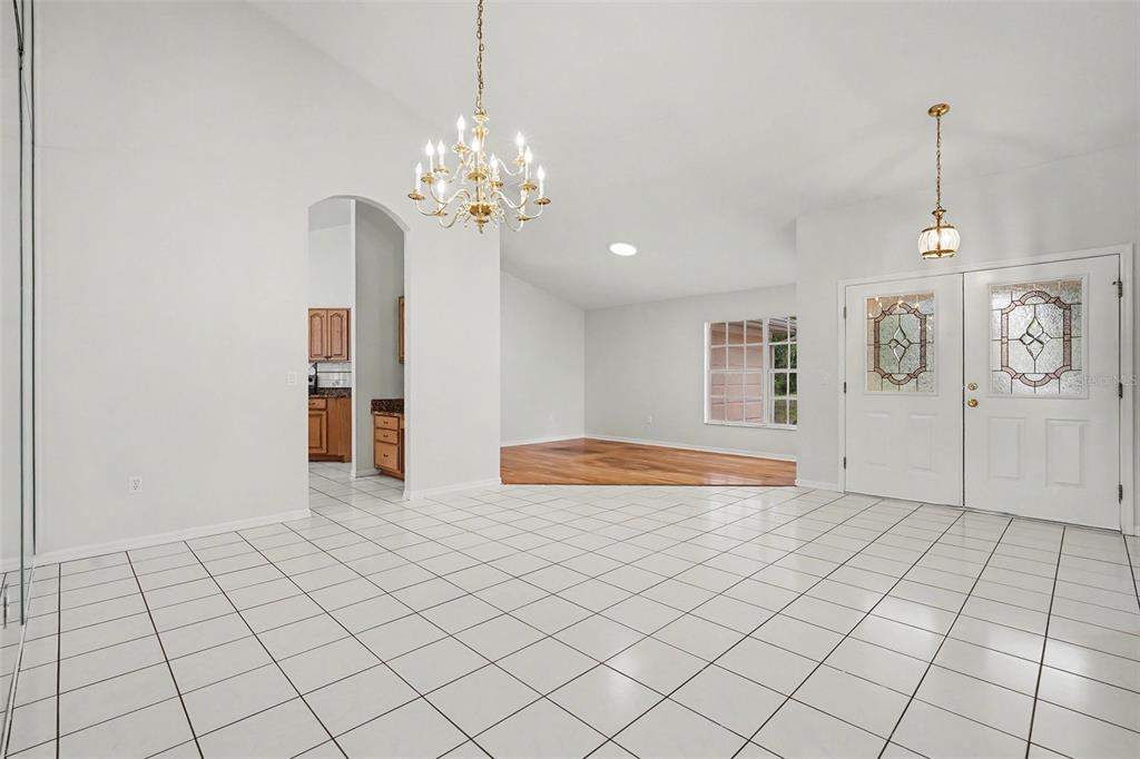 A tiled foyer leads to a living area with hardwood floors and a crystal chandelier — 4814 TANNERY AVENUE, TAMPA, FL