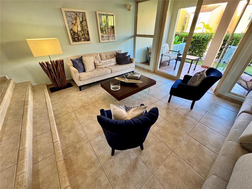 A living room features tile flooring, a sofa, two armchairs, and a sliding glass door — 90 CANDELERO DRIVE UNIT 120, HUMACAO, PR