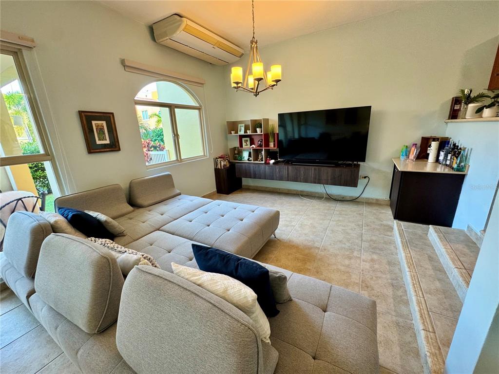 A living room features a large sectional sofa, a wall-mounted television, and tile flooring — 90 CANDELERO DRIVE UNIT 120, HUMACAO, PR