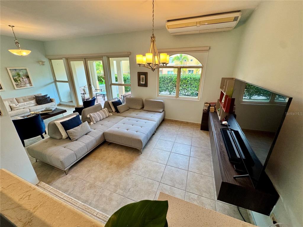 A living room features a large gray sectional sofa, a television console, and tile flooring — 90 CANDELERO DRIVE UNIT 120, HUMACAO, PR
