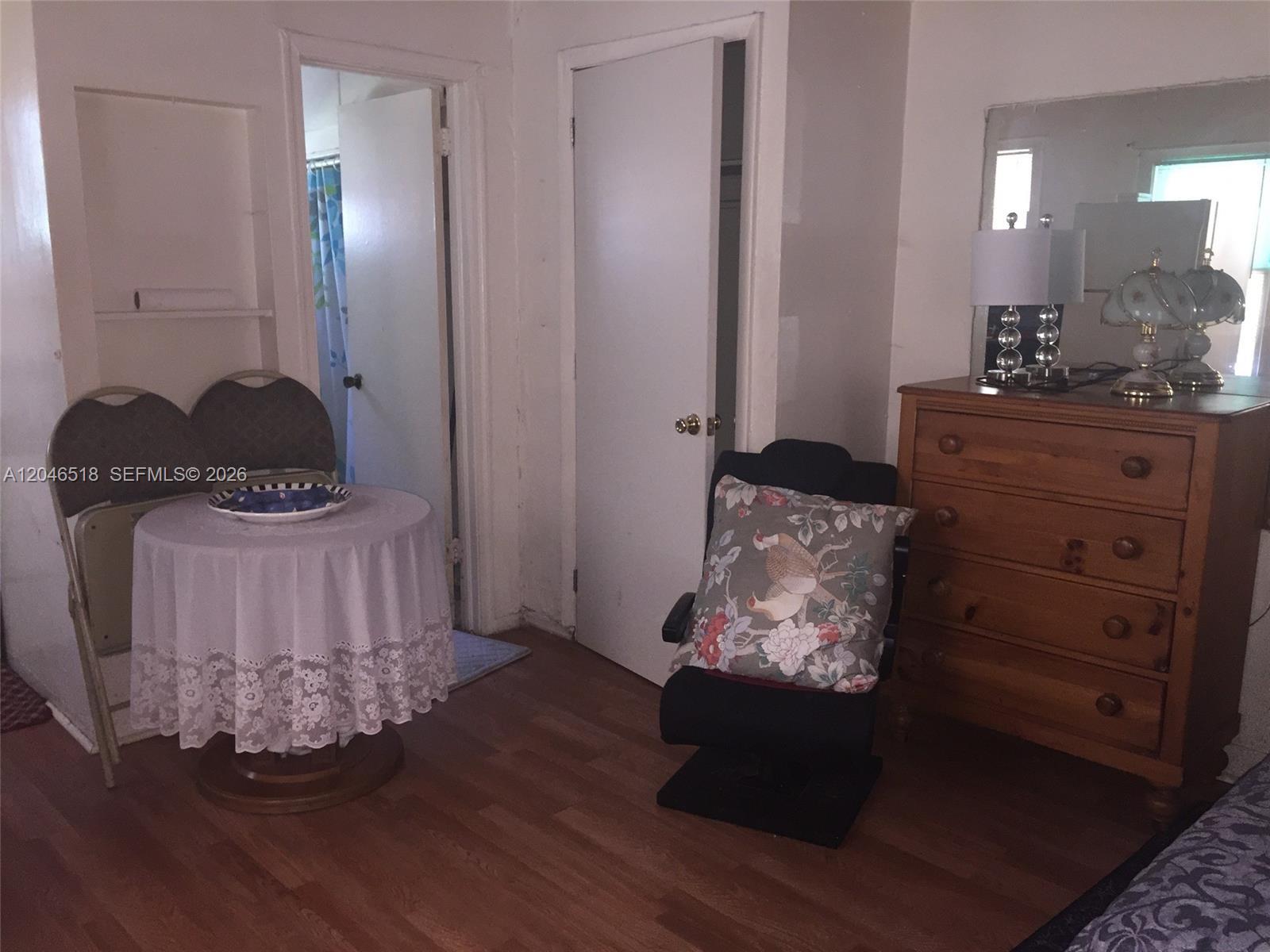 A bedroom features a wooden dresser, a small round table with chairs, and two doorways — 22 SW 11th St, Dania Beach FL 33004, DANIA BEACH, FL