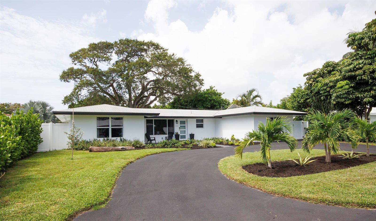 A white single-story house features a curved asphalt driveway and a large mature tree — 1950 NE 30th Street, Lighthouse Point FL 33064, LIGHTHOUSE POINT, FL