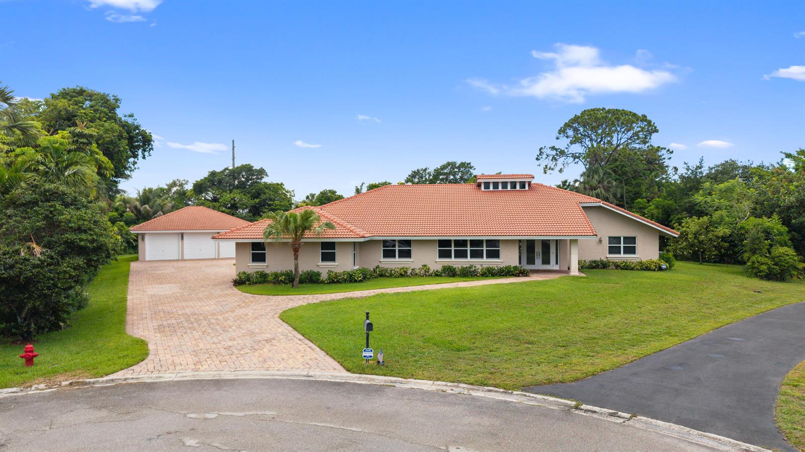 A single-story house with a terracotta tile roof, beige stucco walls, and a paved driveway — 22829 Horse Shoe Way, Boca Raton FL 33428, BOCA RATON, FL