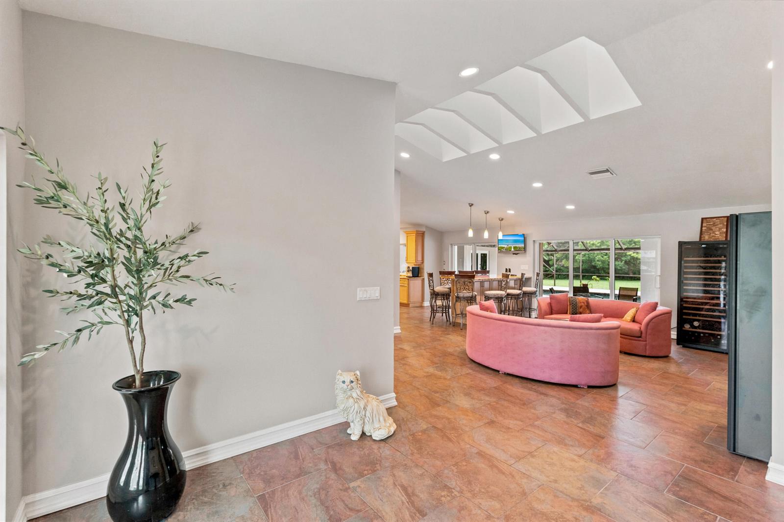 A living room with tile floors, a pink curved sofa, and a skylight ceiling feature — 22829 Horse Shoe Way, Boca Raton FL 33428, BOCA RATON, FL