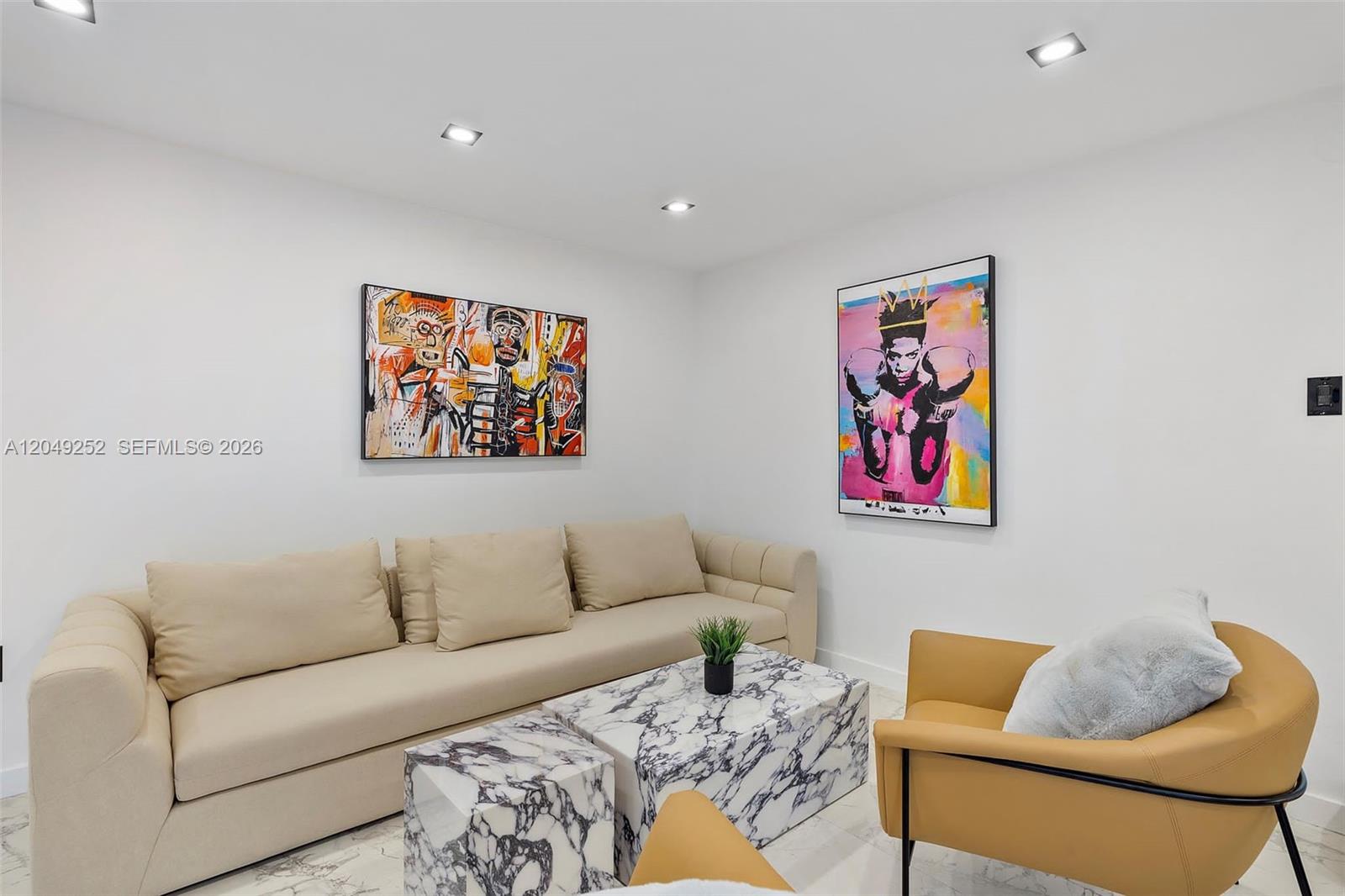 A living room features a beige sofa, two marble coffee tables, and two colorful wall paintings — 501 NW 46th St # 0, Miami FL 33127, MIAMI, FL