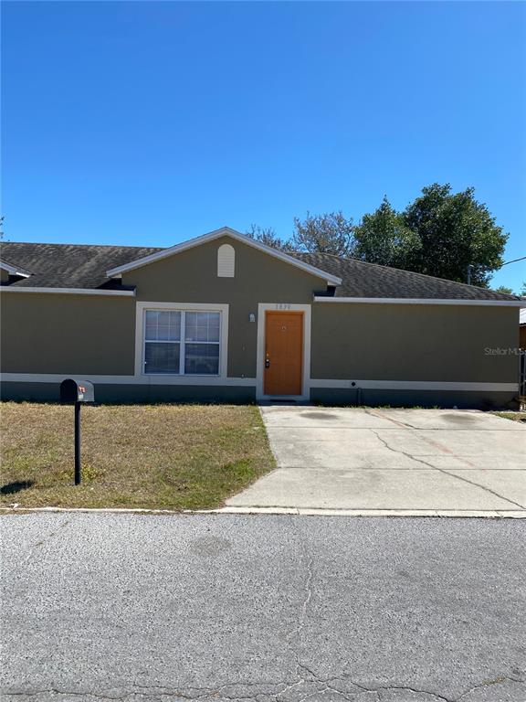 A single-story house with a tan exterior, a brown front door, and a concrete driveway — 1830 2ND STREET NW UNIT A, WINTER HAVEN, FL