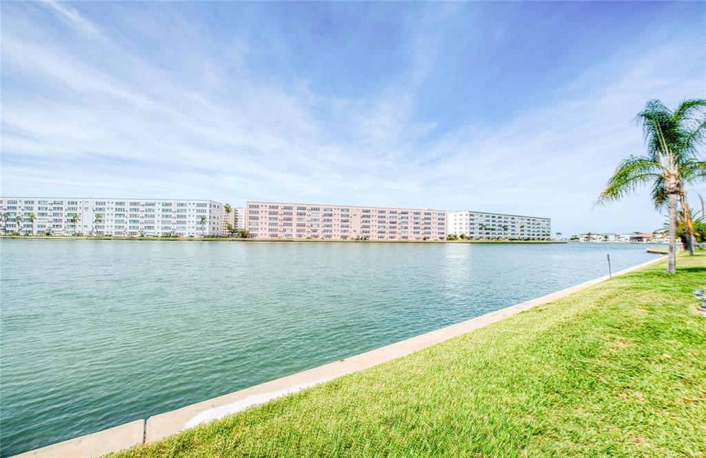 A view of a calm waterway bordered by a grassy lawn and large apartment buildings — 5940 30TH AVENUE S UNIT 115, GULFPORT, FL
