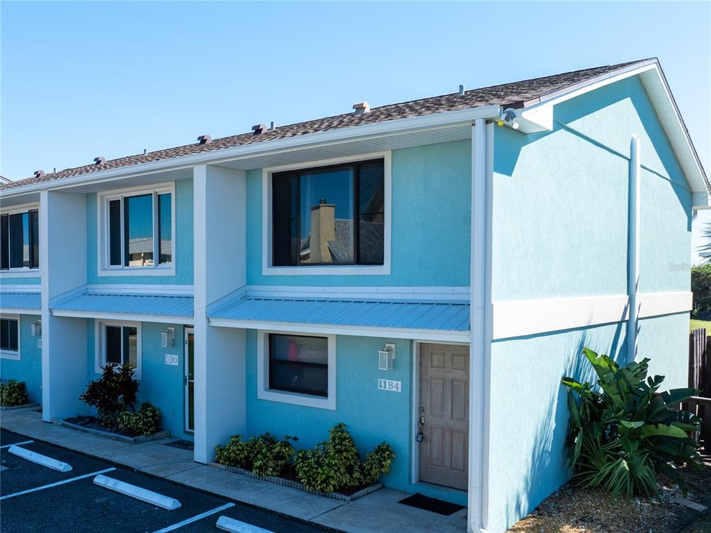 A two-story light blue building with white trim, a metal awning, and parking spaces — 4786 S ATLANTIC AVENUE UNIT 4B, PONCE INLET, FL