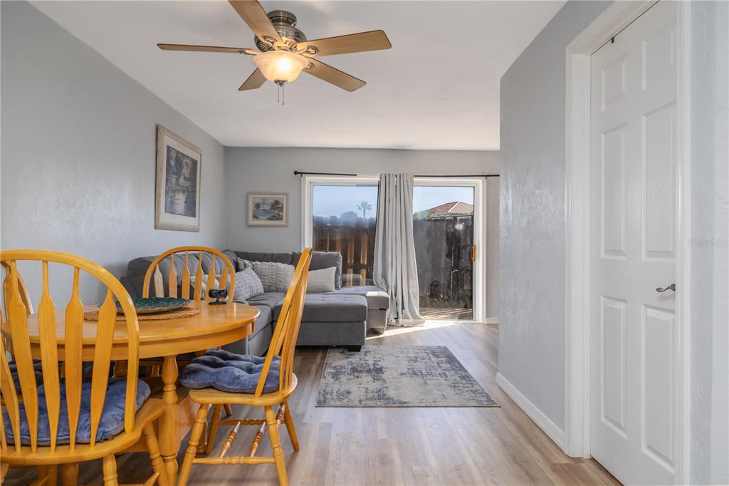 A dining area with a wooden table and chairs opens into a living room space — 4786 S ATLANTIC AVENUE UNIT 4B, PONCE INLET, FL