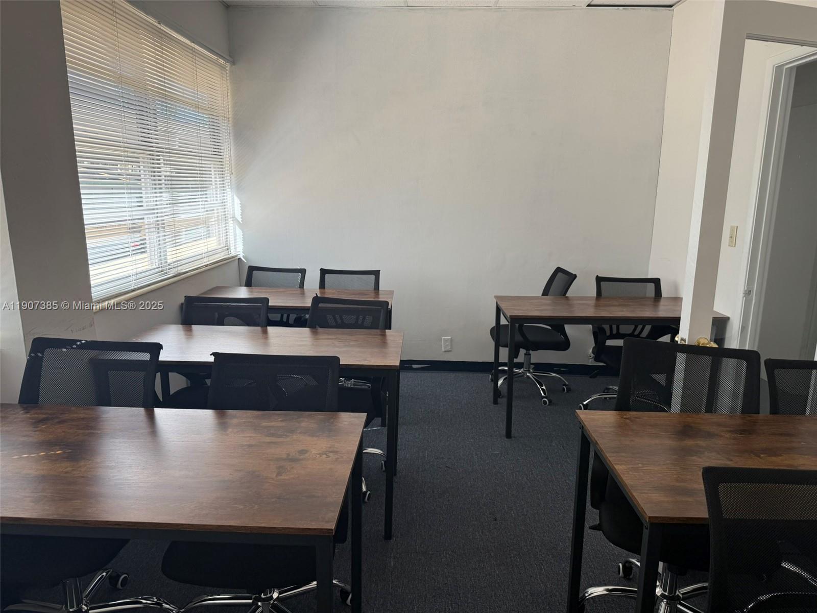 An office space features several desks with black mesh chairs on a carpeted floor — 220 Miracle Mile # B236, Coral Gables FL 33134, CORAL GABLES, FL