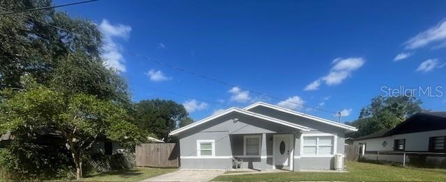 A single-story gray house with a white front door and a small concrete porch — 7712 DELEUIL AVENUE, TAMPA, FL