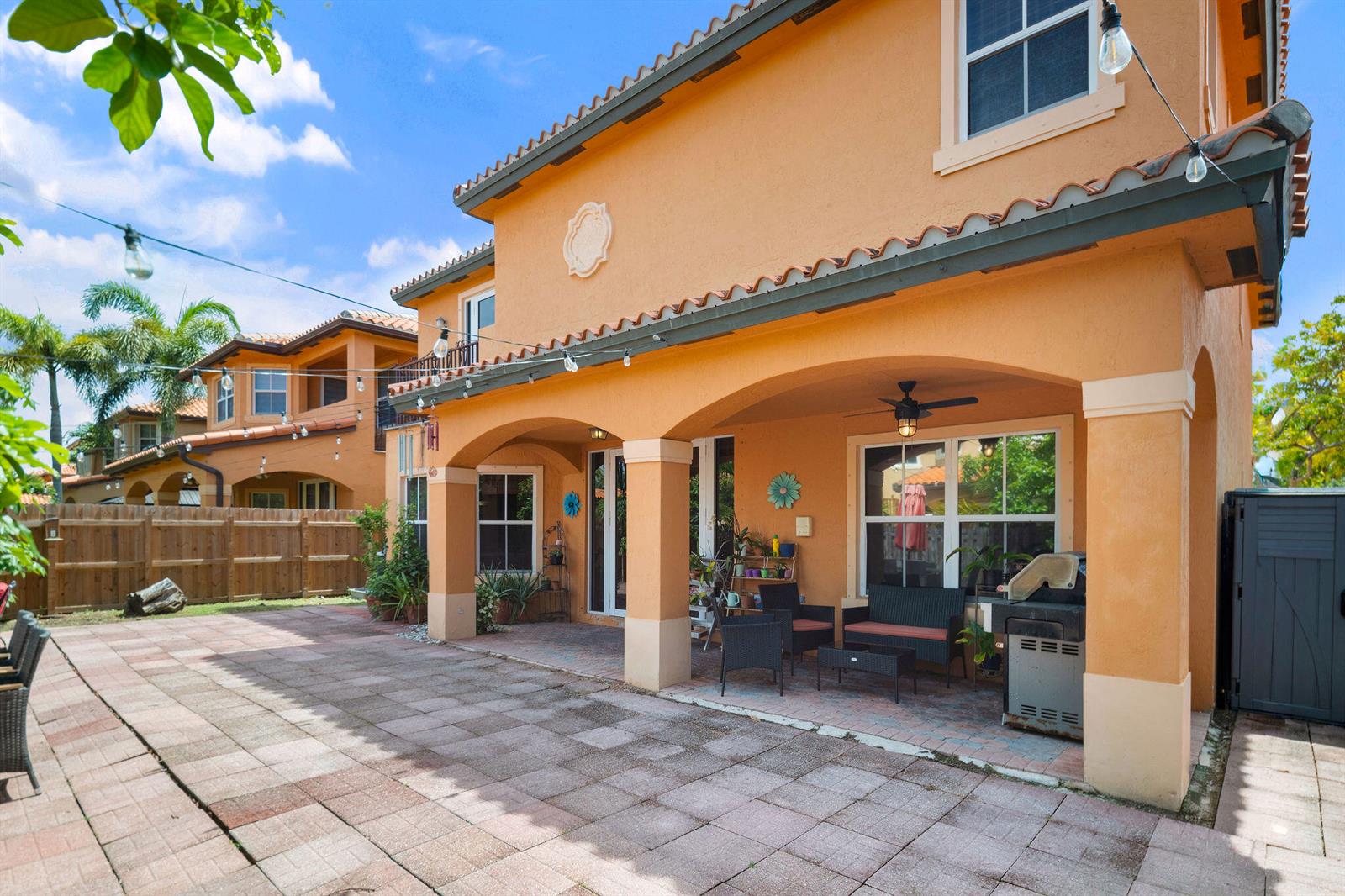 A two-story orange stucco house features a covered patio with outdoor seating and a grill — 3144 SW 154th Place, Miami FL 33185, MIAMI, FL