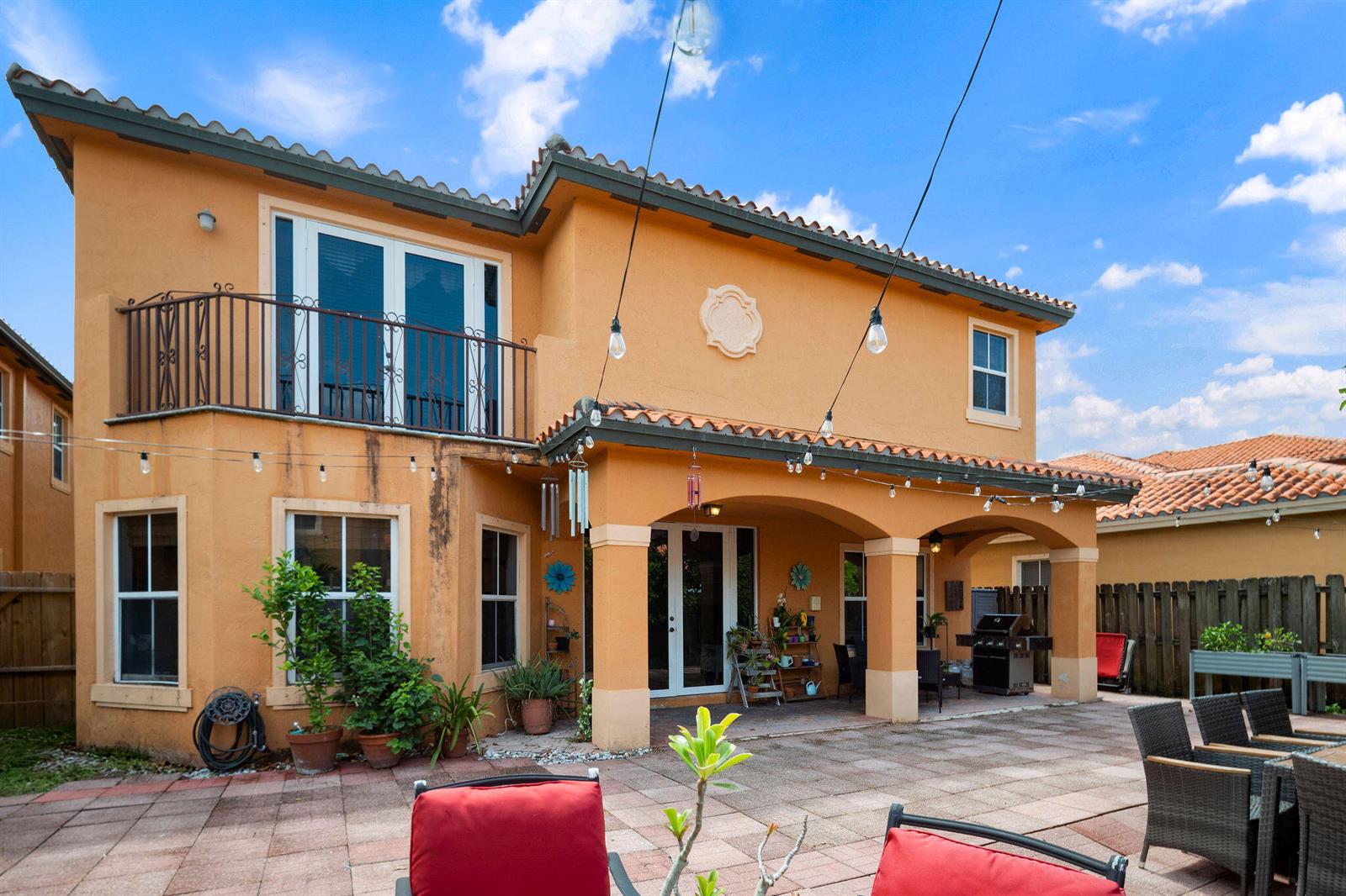 The exterior of a two-story stucco house features a balcony, covered patio, and paved backyard — 3144 SW 154th Place, Miami FL 33185, MIAMI, FL