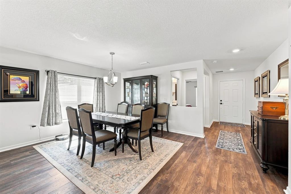 A dining room with a dark wood table, six chairs, and a hutch on wood flooring — 455 OVERPOOL AVENUE, DAVENPORT, FL
