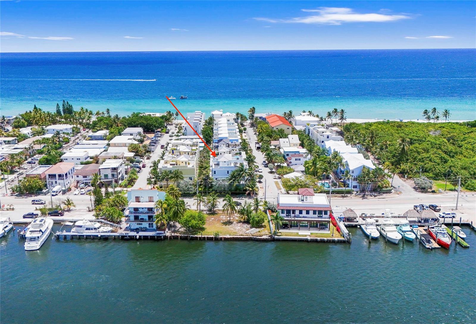 An aerial view shows a coastal neighborhood with multi-story buildings, palm trees, and boat docks — 347 Oak Street # B1, Hollywood FL 33019, HOLLYWOOD, FL