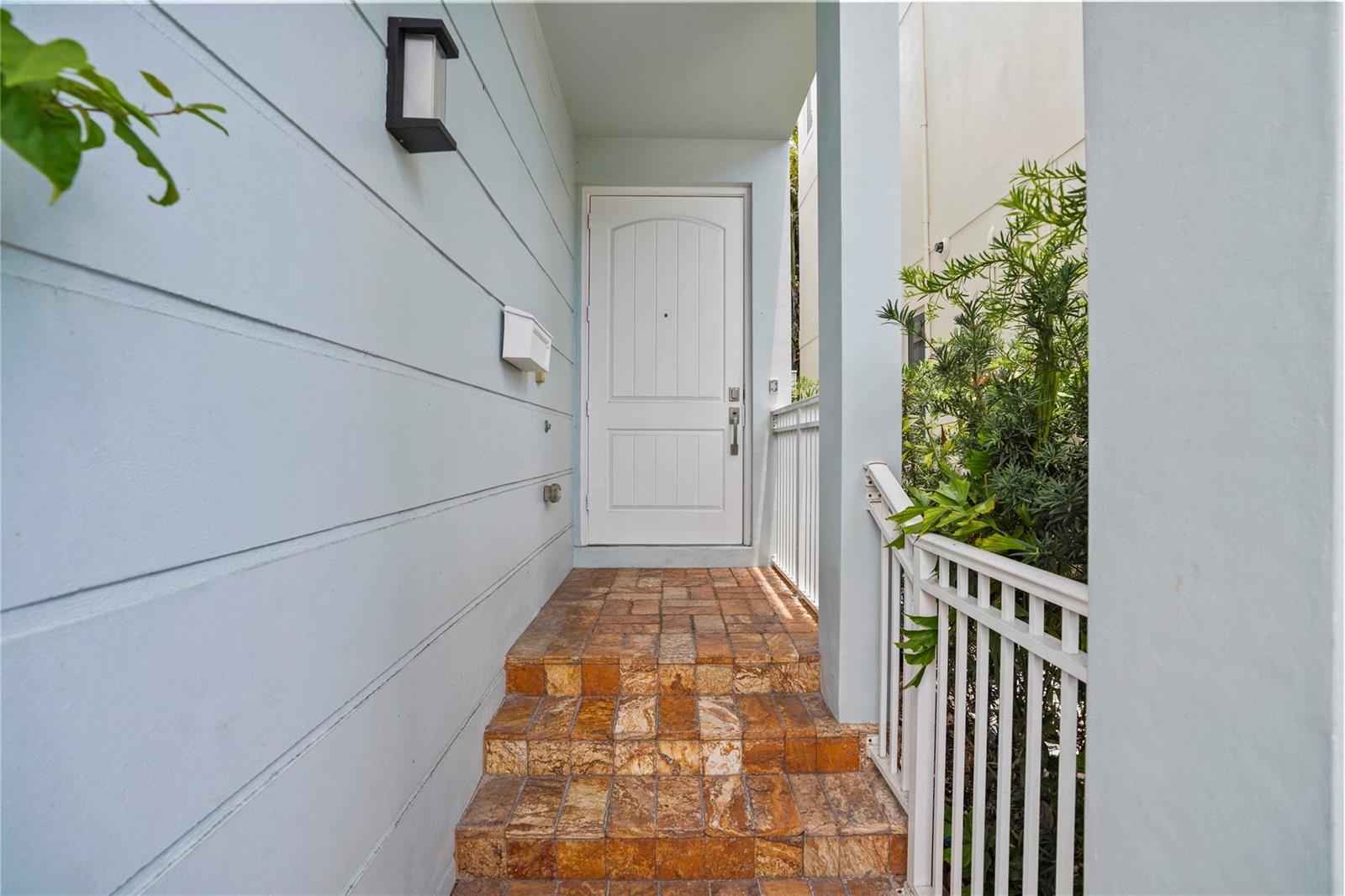 A white front door is accessed by a set of stone steps with a white railing — 347 Oak Street # B1, Hollywood FL 33019, HOLLYWOOD, FL