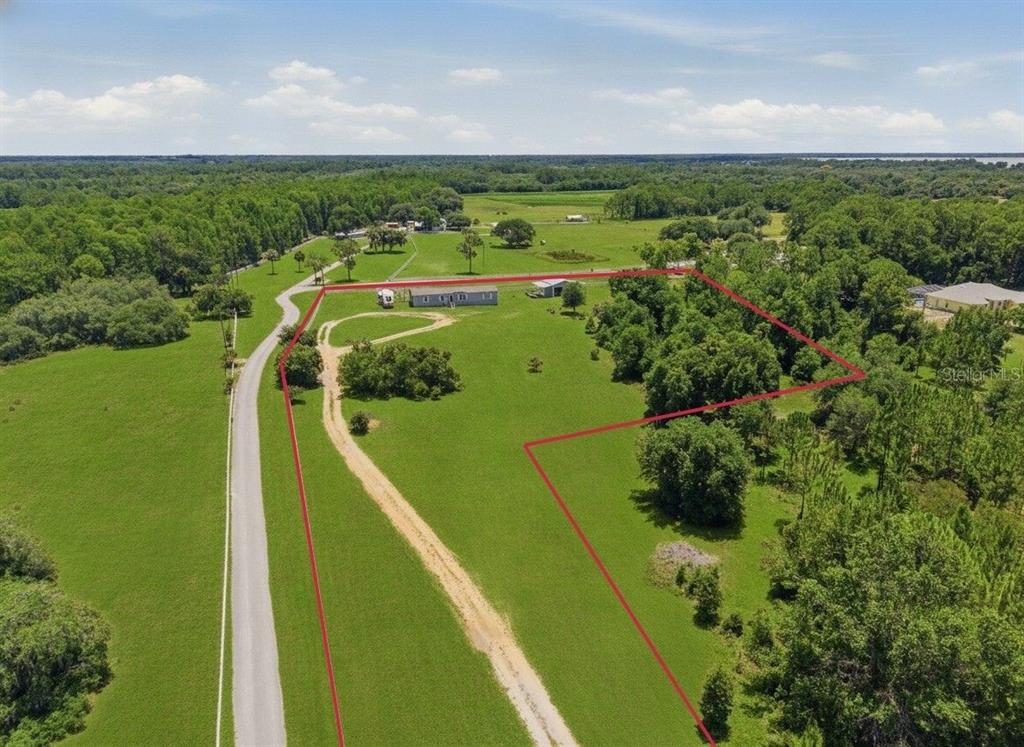 An aerial view shows a rural property with a house, outbuilding, and driveway outlined in red — 7242 BLACK ROAD, LAKE WALES, FL
