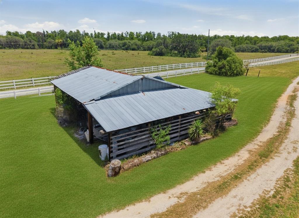 An aerial view shows a weathered barn with a metal roof on a grassy lot — 7242 BLACK ROAD, LAKE WALES, FL