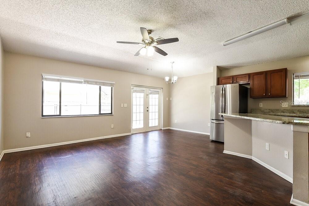 An open-concept living and dining area features dark wood flooring, a ceiling fan, and kitchen — 534 S SUNDANCE DRIVE, LAKE MARY, FL