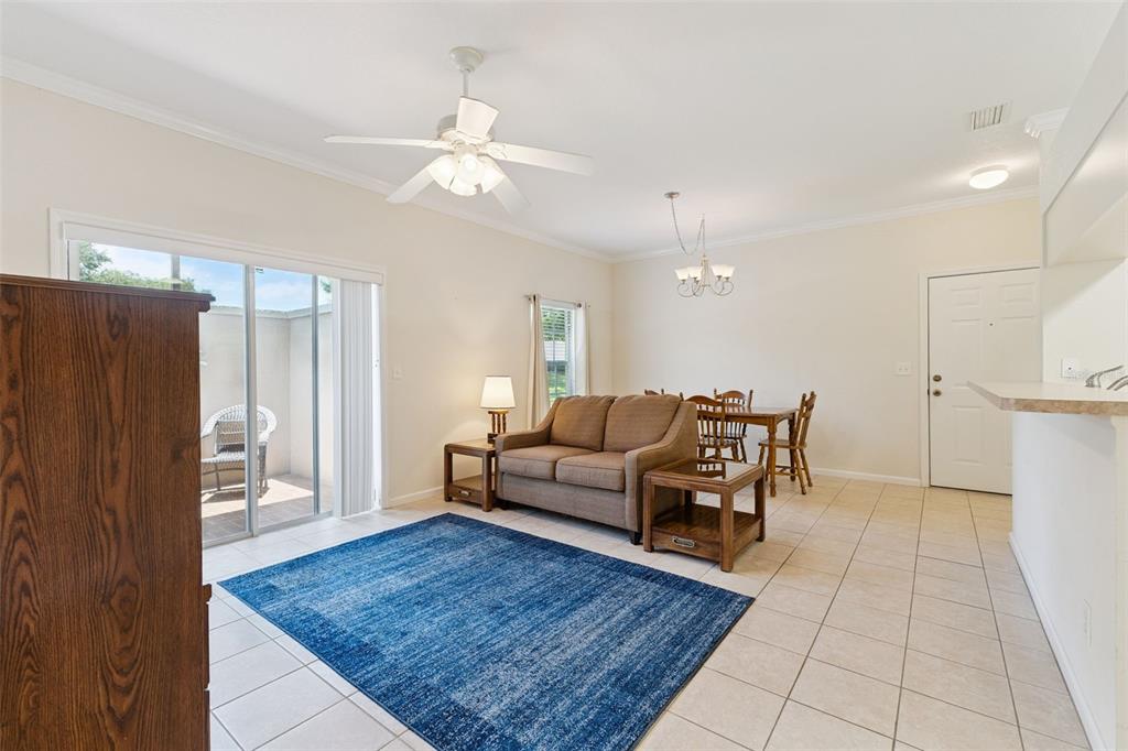 A living and dining area features tile flooring, a blue rug, and a ceiling fan — 1502 EAGLE POND DRIVE UNIT 15, WINTER HAVEN, FL