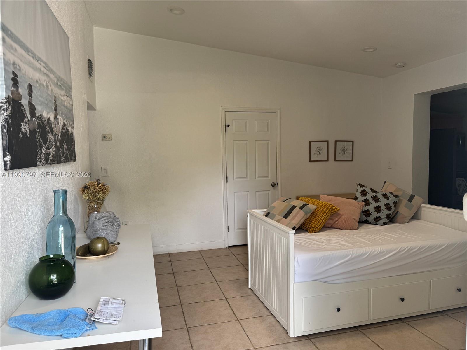 A room features a white daybed, a white desk with decorative items, and tile flooring — 6126 SW 61st St, South Miami FL 33143, SOUTH MIAMI, FL