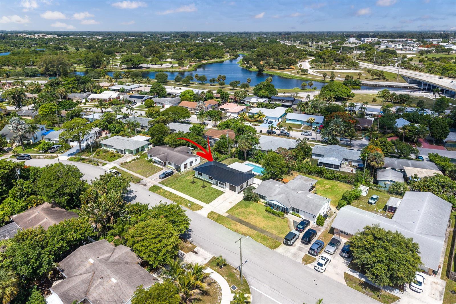 An aerial view of a suburban house with a dark roof and a backyard pool — 707 Sunset Drive, FL 33461, FL