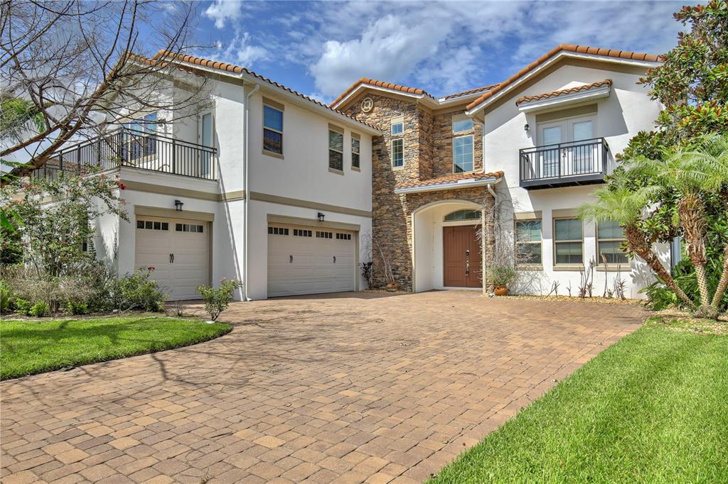 A two-story house with a stone facade, a paved driveway, and two garage doors — 10822 MOBBERLEY CIRCLE, ORLANDO, FL