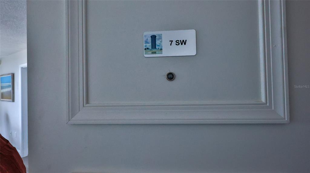 A close-up view of a door featuring a sign labeled 7 SW and a peephole — 2625 S ATLANTIC AVENUE UNIT 7SW, DAYTONA BEACH SHORES, FL